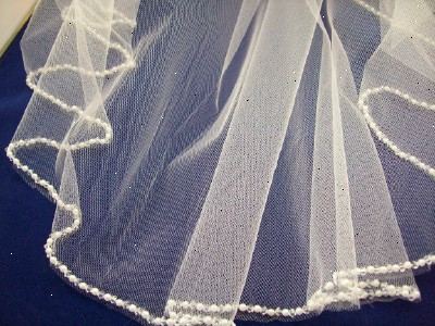 Hoe te decoratieve kralen naaien op een bruiloft sluier. Bereid uw sluier en de kralen die je gaat gebruiken.
